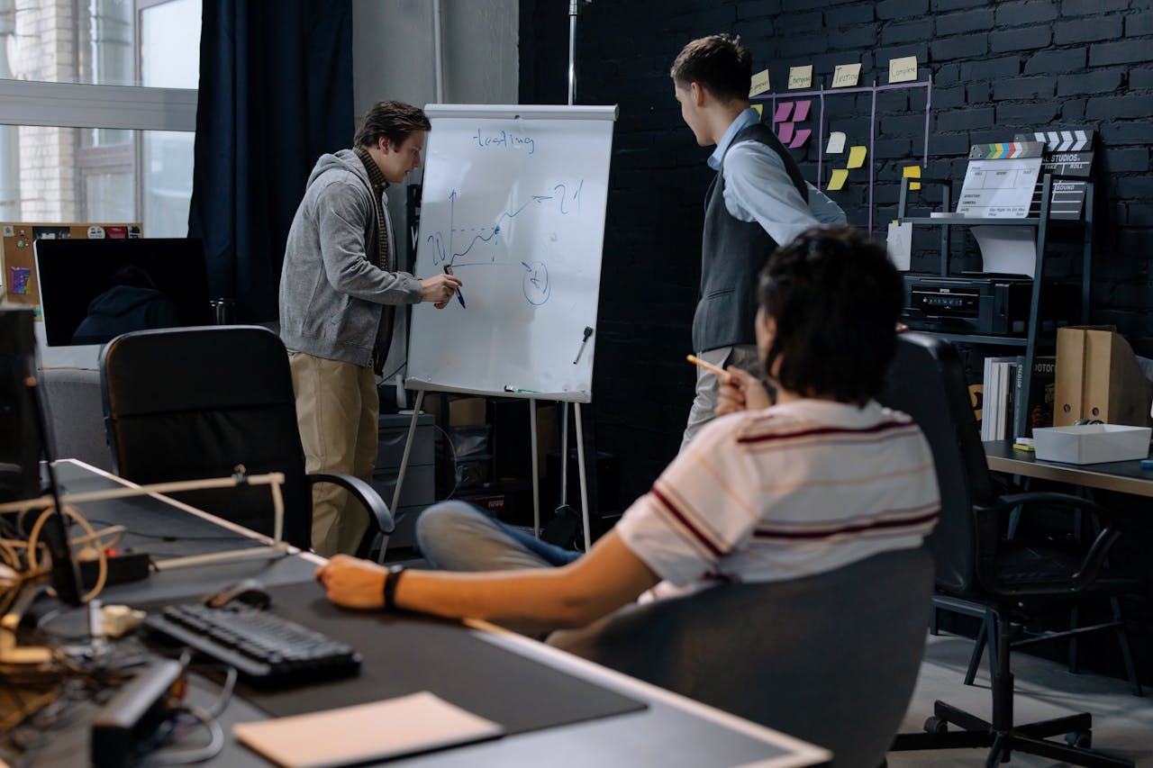 services-02 Business team in a modern office brainstorming ideas on a whiteboard. Engaged discussion and planning.