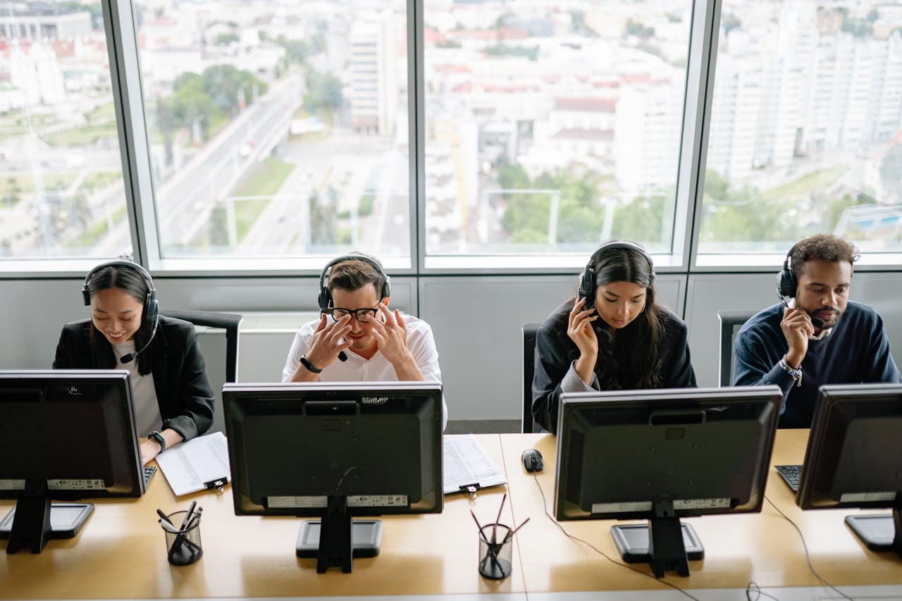 why-choose-us Group of diverse call center employees working at computers in a modern office setting.